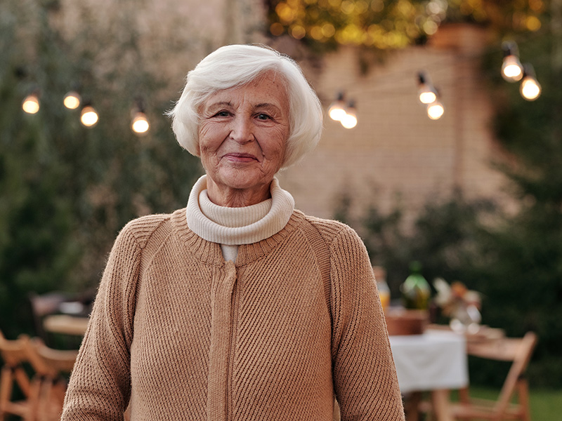 Older woman smiling at outdoor dinner