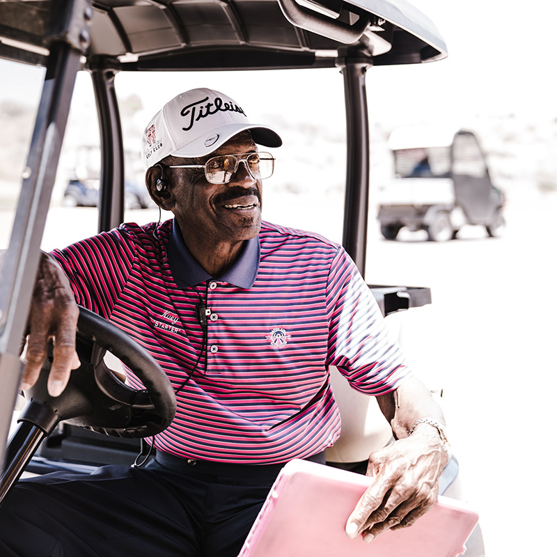 Older man leaning out of a golf cart